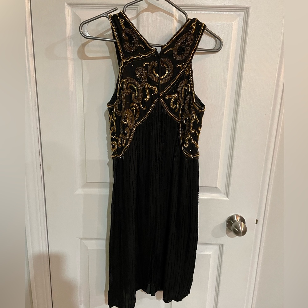 All silk hand beaded black dress with gold beading . Fits as women’s small .